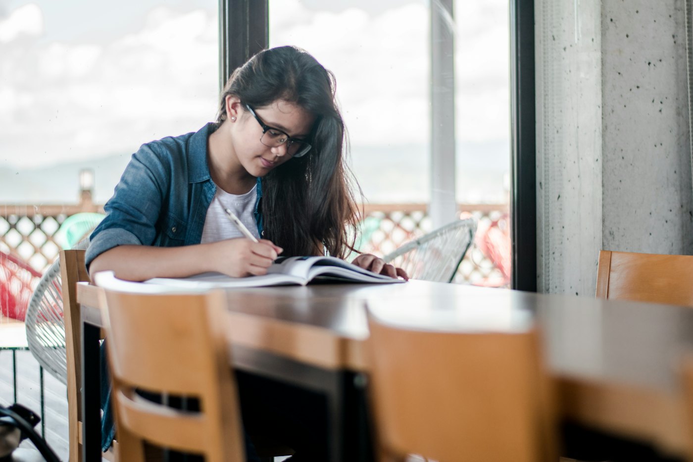 A high school learner works through problems in her notebook